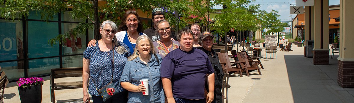 Visitors from Optimae's Recovery & Resource Center group poses for a photo at an outdoor shopping mall